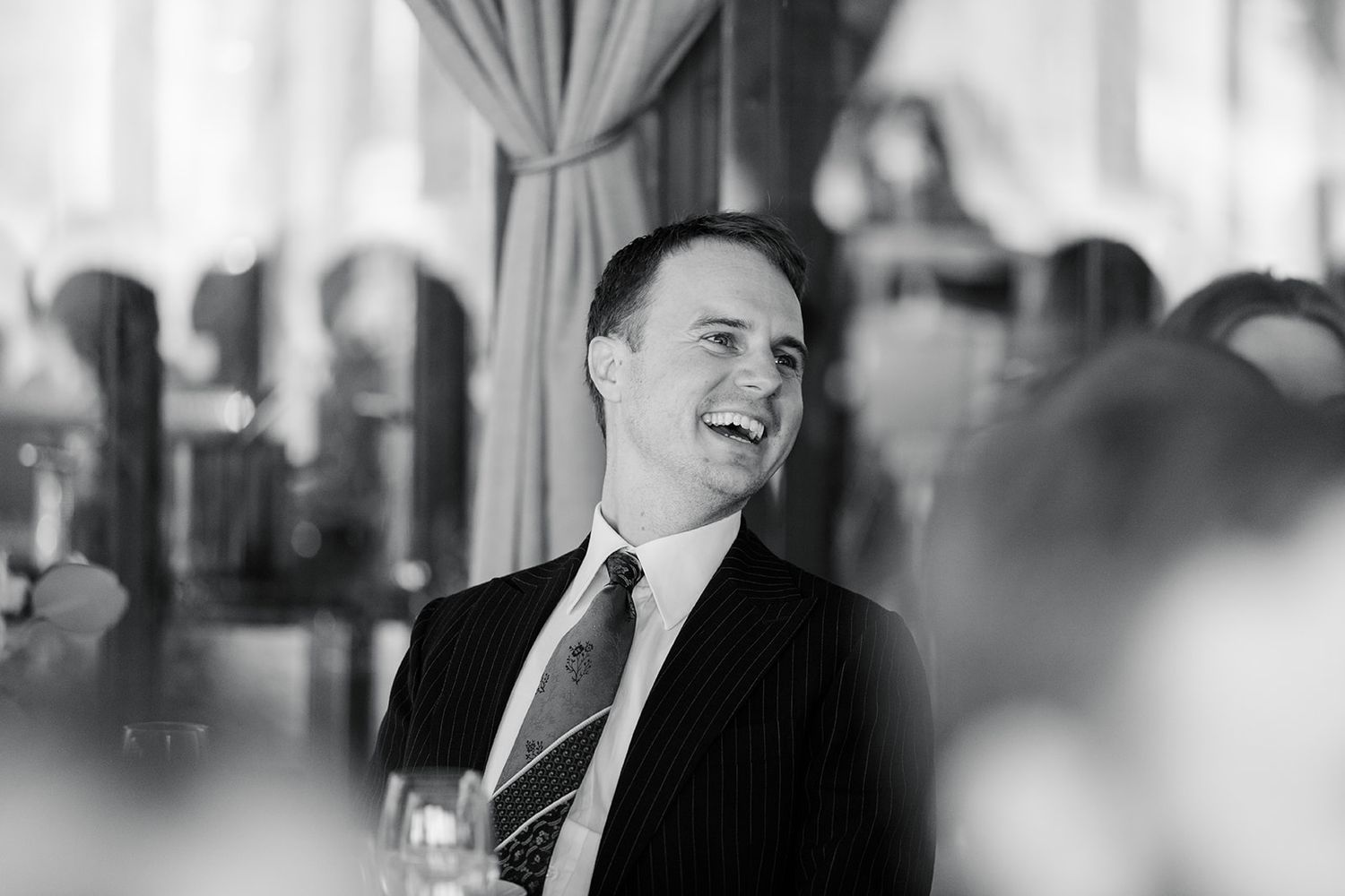 A black and white photo sequence shows candid expressions and laughter in a casual indoor setting.