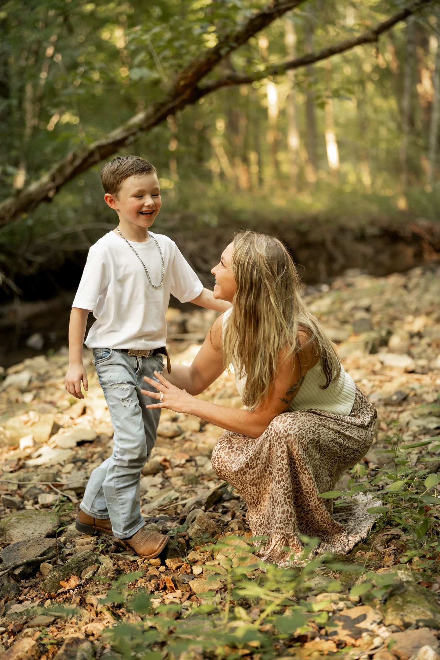 Candid moments of playful interaction in a wooded area with autumn leaves on the ground.