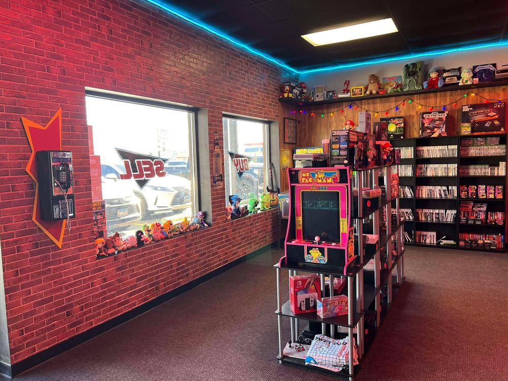 Interior view of a retro toy store with red brick walls and blue neon lighting accents.