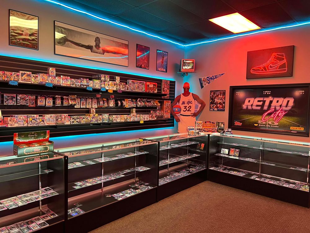 Gaming retail space with glass display cases and neon lighting showcasing retro video game merchandise.