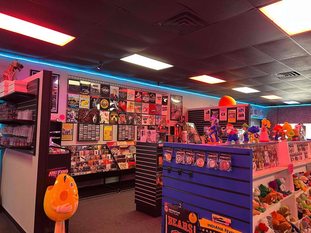 Vintage video game store with colorful lighting and wall-to-wall gaming merchandise displays.