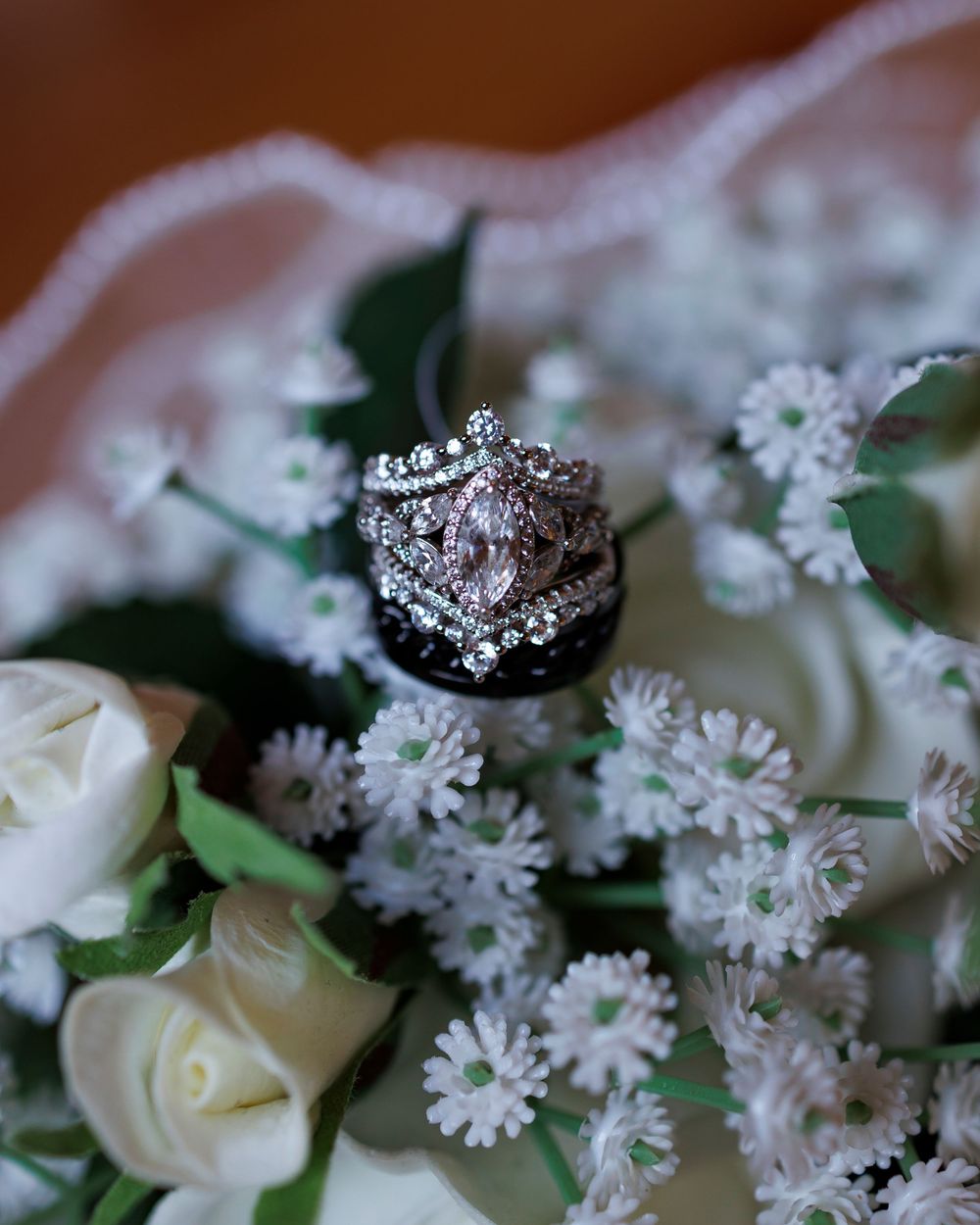 White roses and delicate baby's breath flowers arranged with greenery in soft focus.