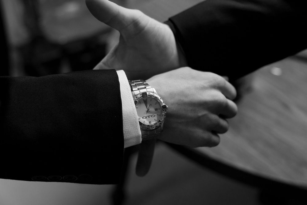 A row of black and white close-up shots showing hands and details from a wedding ceremony.