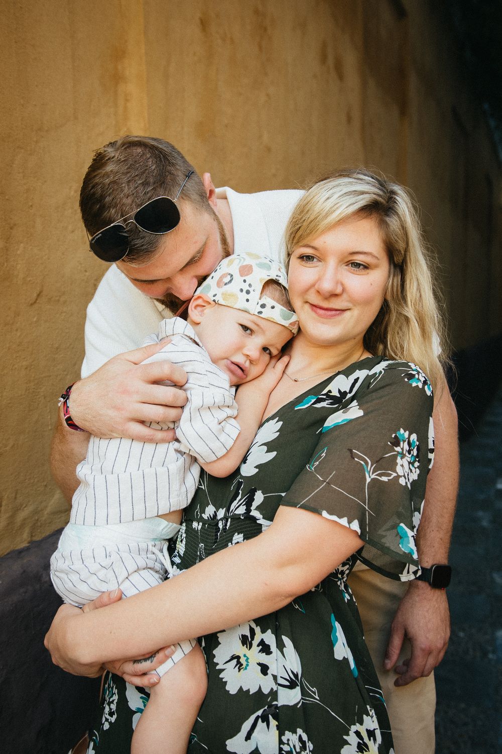 A series of tender family embraces showing affection and closeness against a textured wall background.