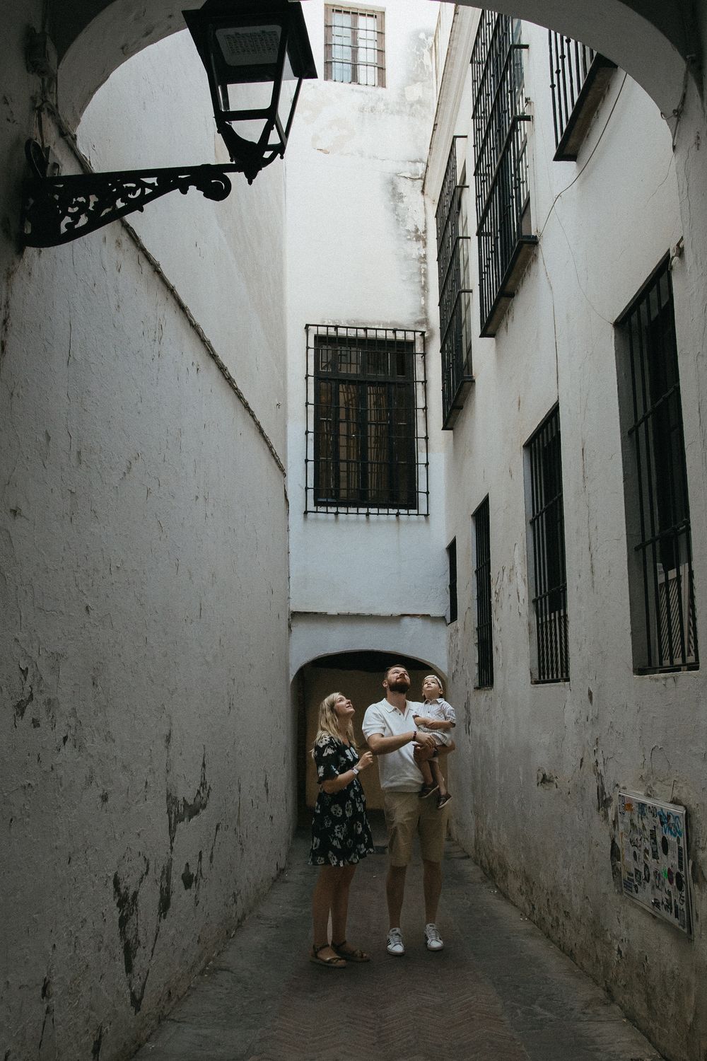 A series of shots capturing a narrow white-walled passageway with an arched ceiling and traditional lanterns.