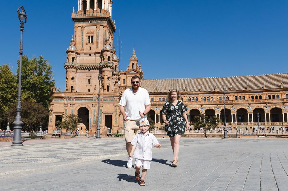 Tourists exploring the historic Plaza de España in Seville with its ornate architecture and grand archways.