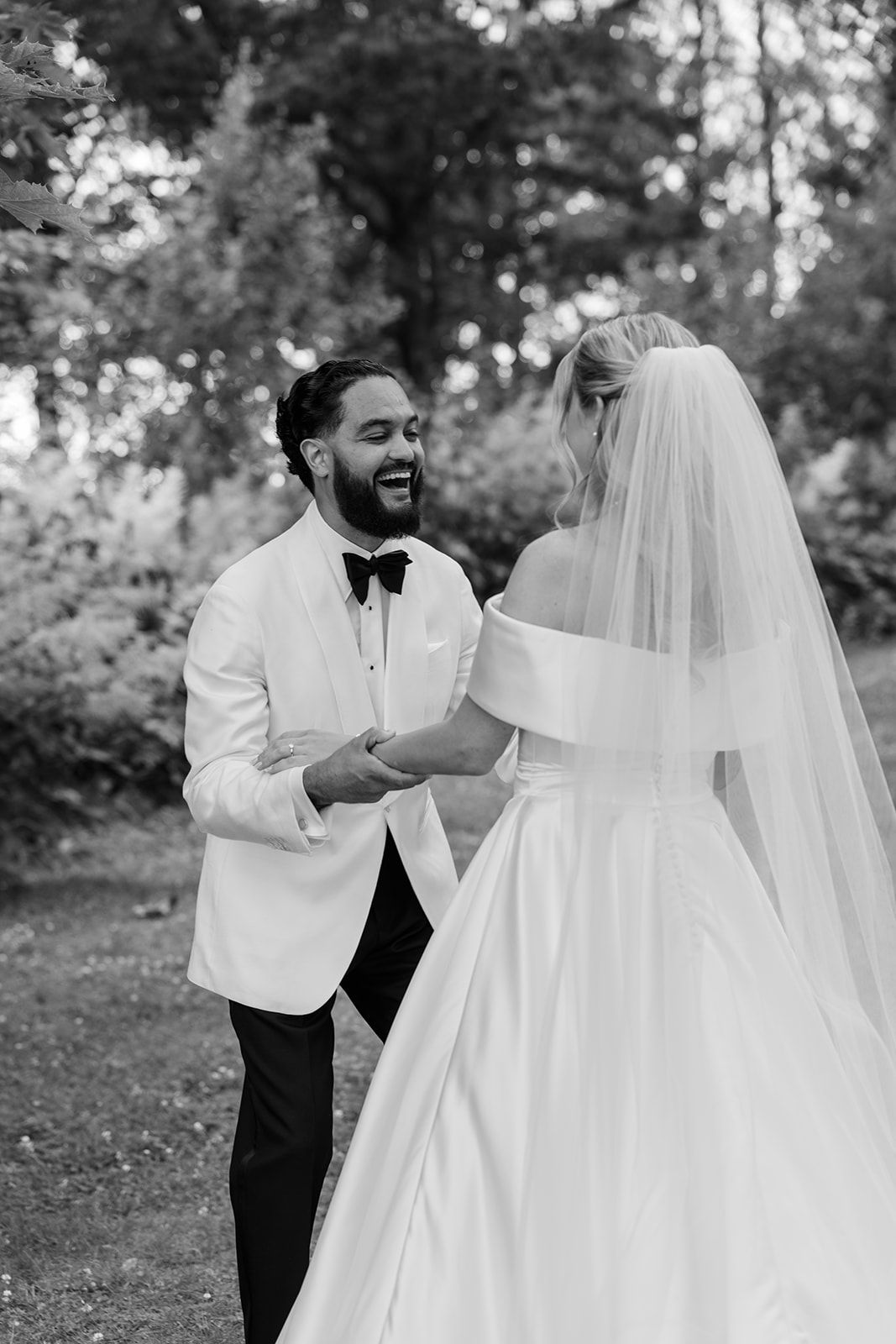 A black and white photo series showing a couple's joyful first look moment during their outdoor wedding celebration.