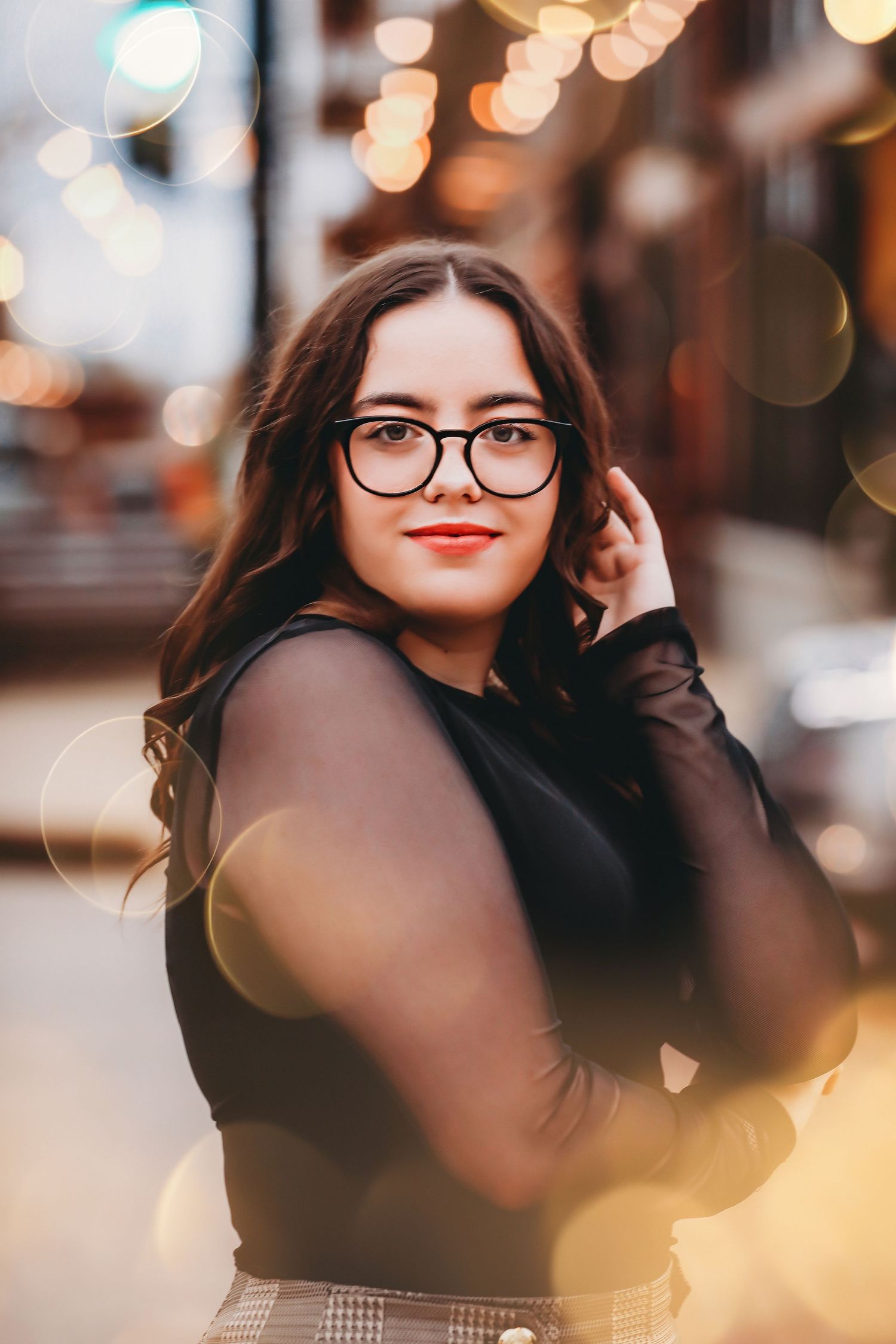 Portrait of someone in glasses and black sweater with bokeh lights in background.
Best photographer in Illinois