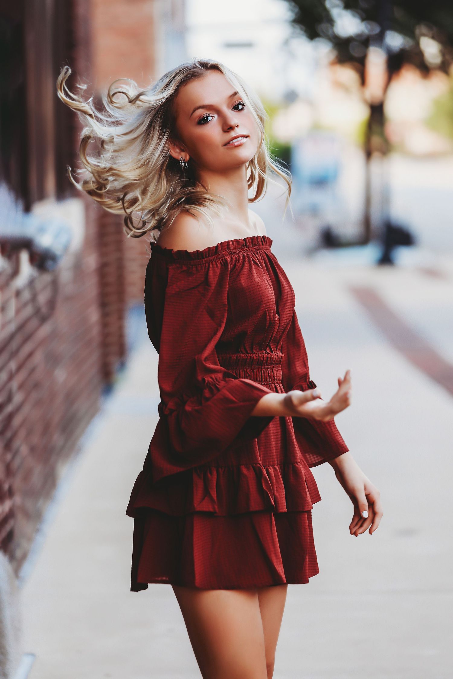 Portrait of someone in a red ruffled dress with wind-blown hair on a city street.

Best photographer in Illinois