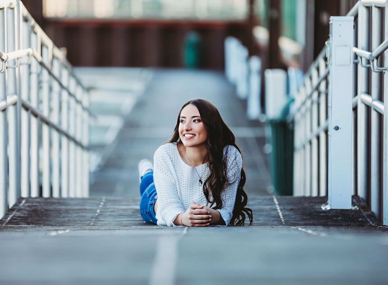 Person lying on white walkway holding coffee cup with railing perspective.

Best teen's photographer in Illinois