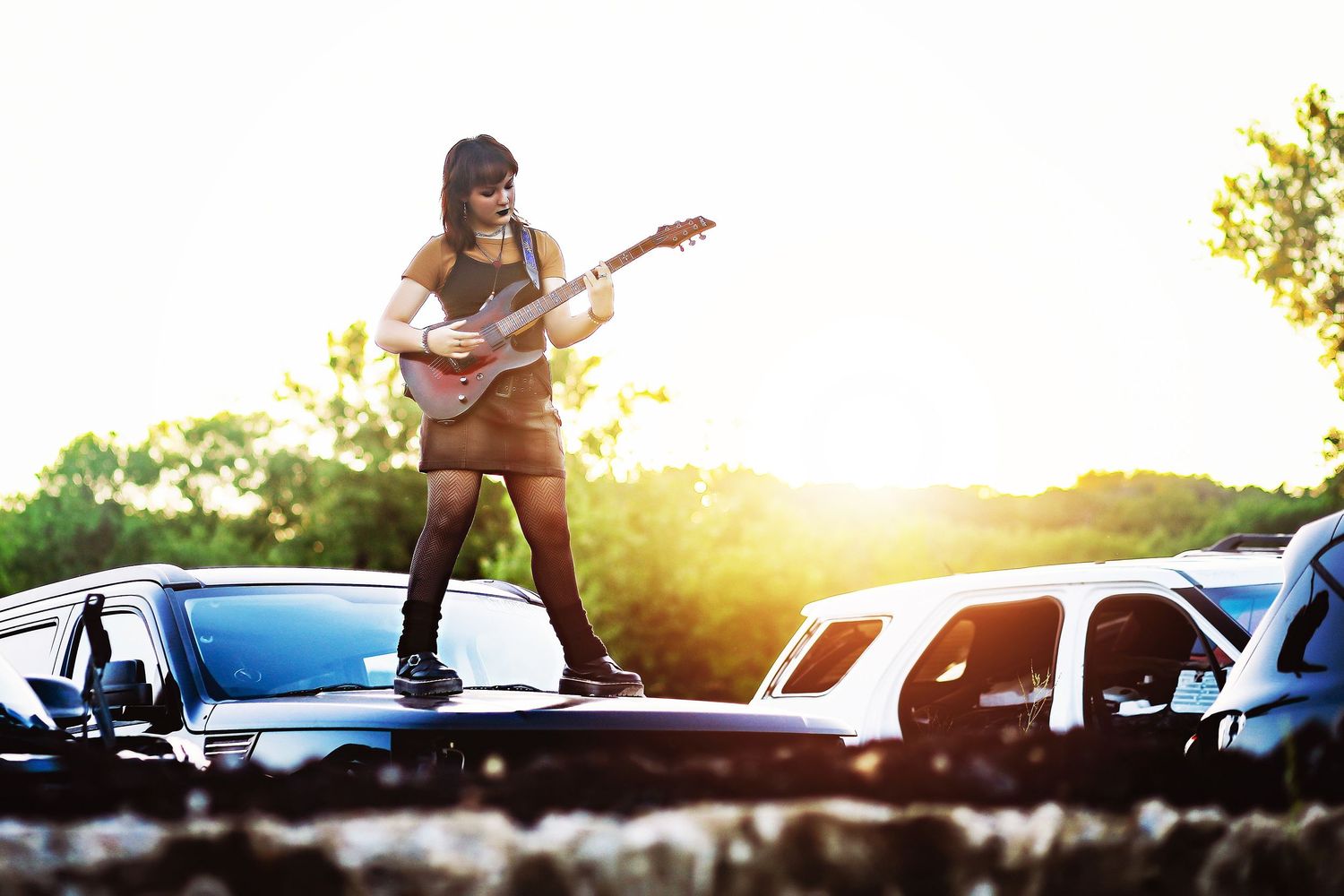 Musician playing guitar while standing on car hood at sunset.

Best teen's photographer in Illinois
