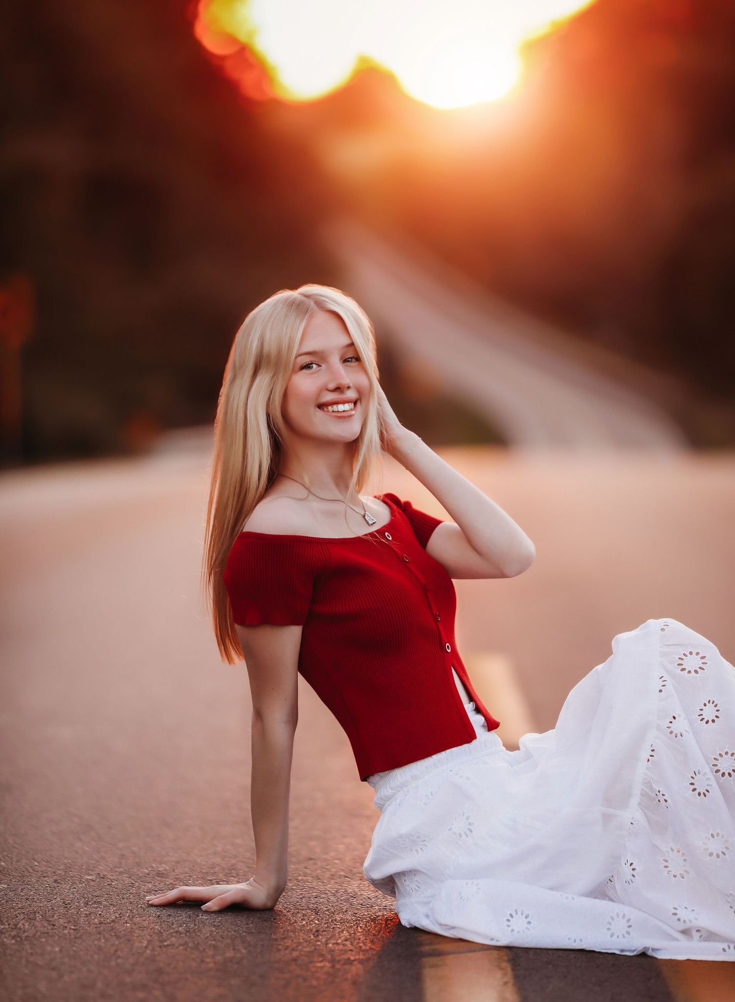 Portrait of someone in a red off-shoulder top and white skirt sitting on the ground at sunset.
Best photographer in Illinois