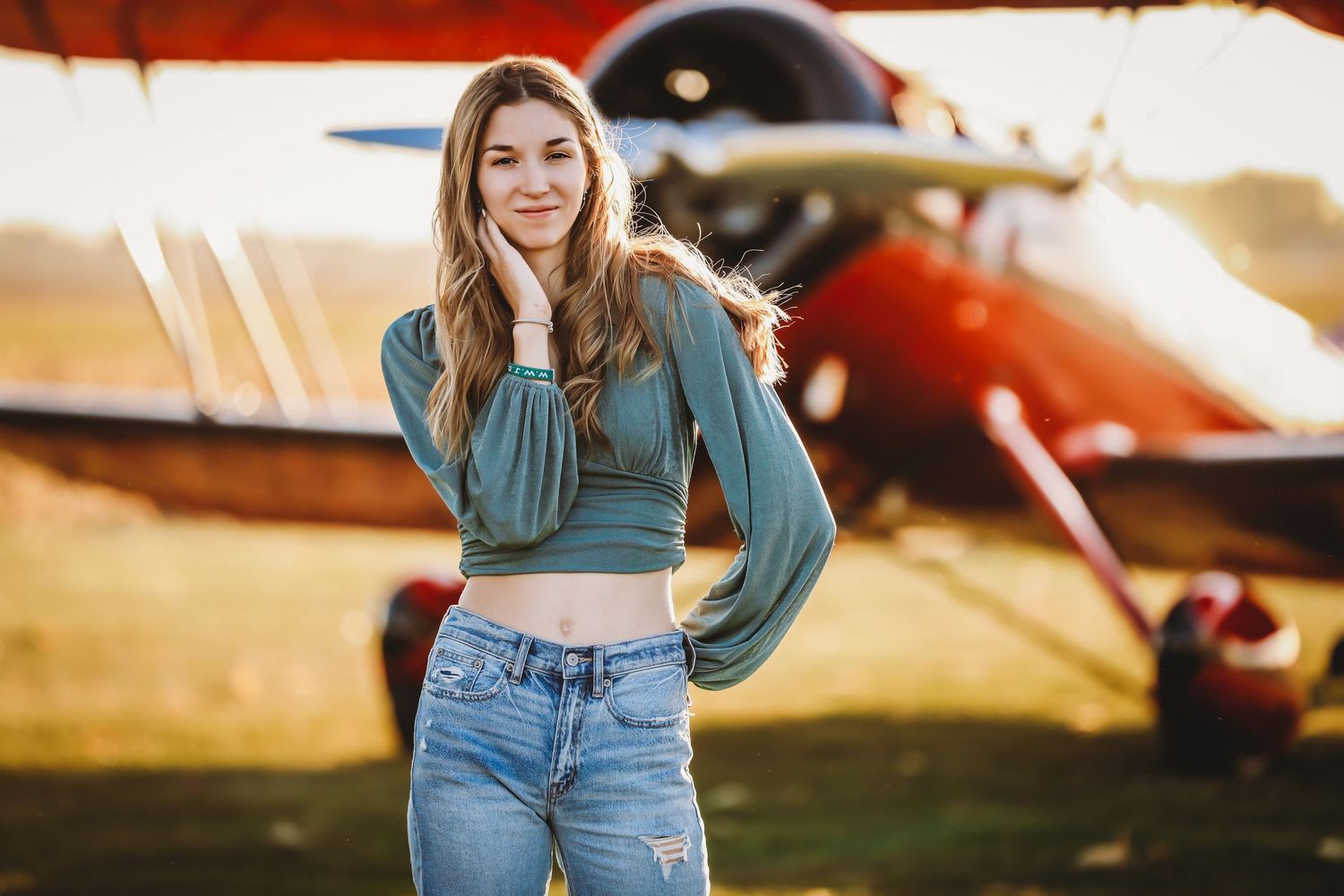Casual portrait of someone in a cropped green top and jeans posing by a vintage airplane.

Best photographer in Illinois
