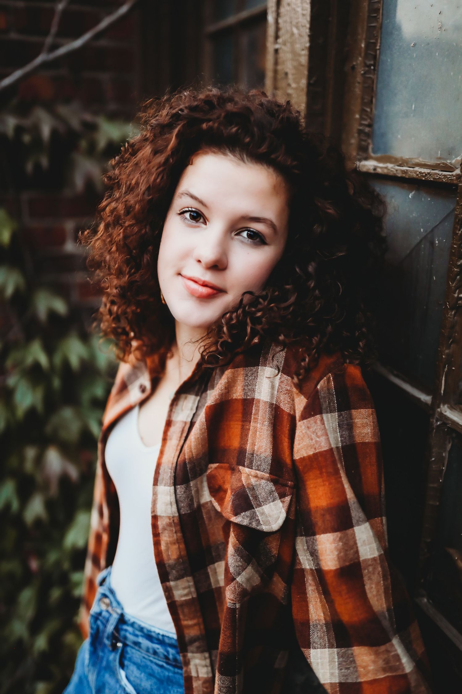 Portrait of someone with curly hair wearing plaid flannel and jeans against rustic wall.

Best teens's photographer in Illinois