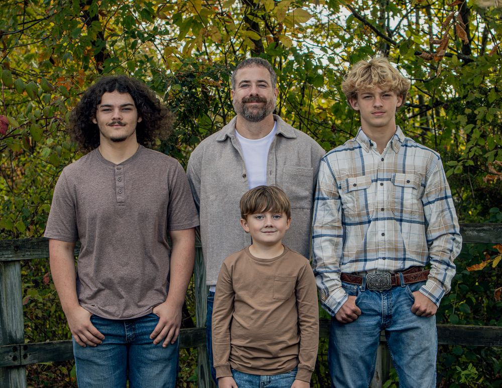 Casual outdoor family portrait with everyone in denim and earth tones.