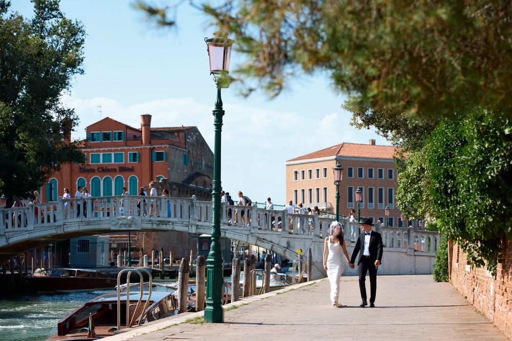 Scenic panoramic view of colorful buildings and canals along Venice's waterfront with traditional architecture and lampposts.
