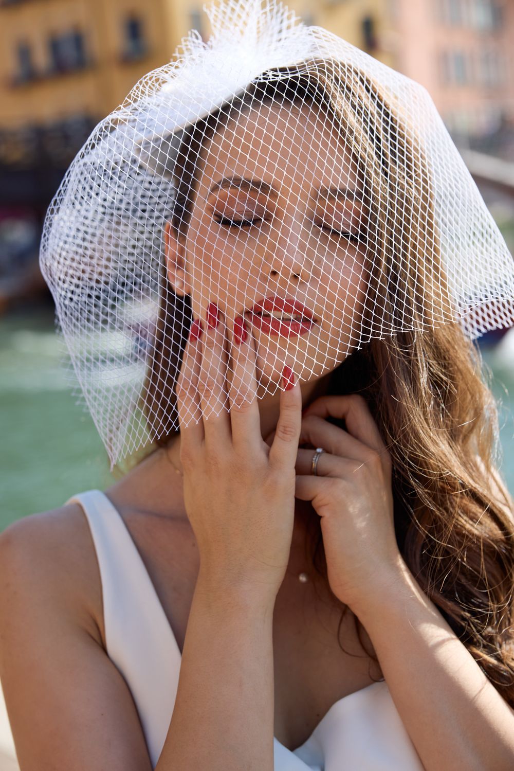 A bride in a white veil covers her face with her hands in a series of candid emotional wedding photos.