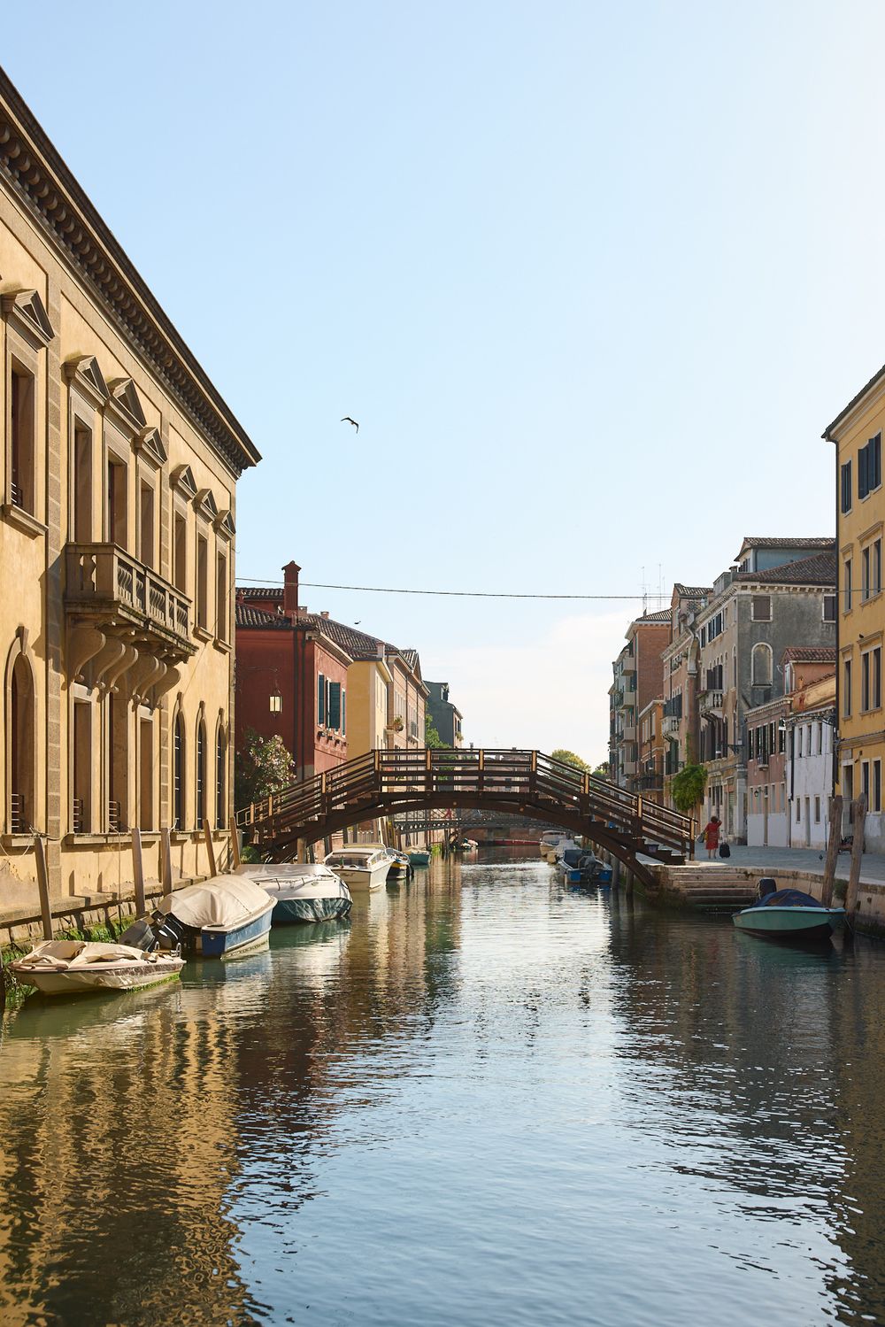 Scenic canal views in Venice with historic buildings and boats reflecting in the tranquil waters.