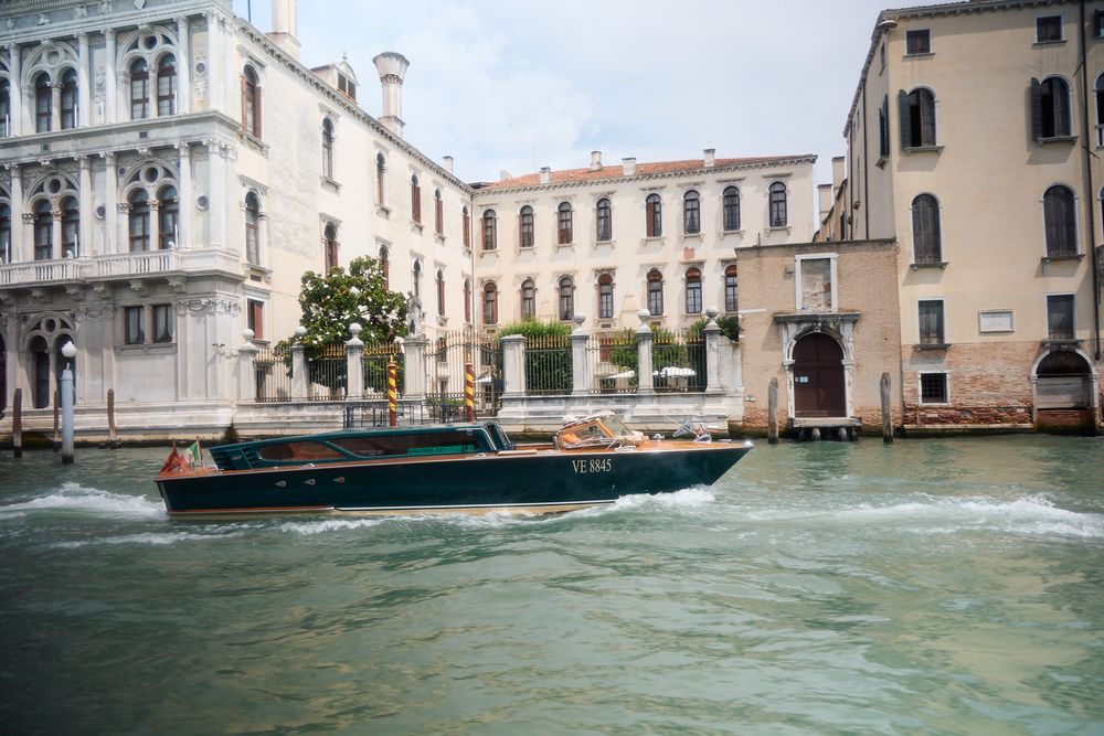 Traditional Venetian canal view with historic buildings and boats along the waterway.