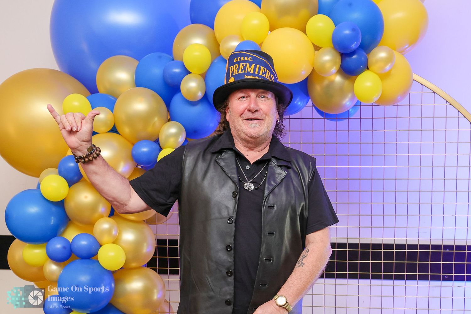Event space decorated with festive blue, yellow and gold balloon garlands and arches.