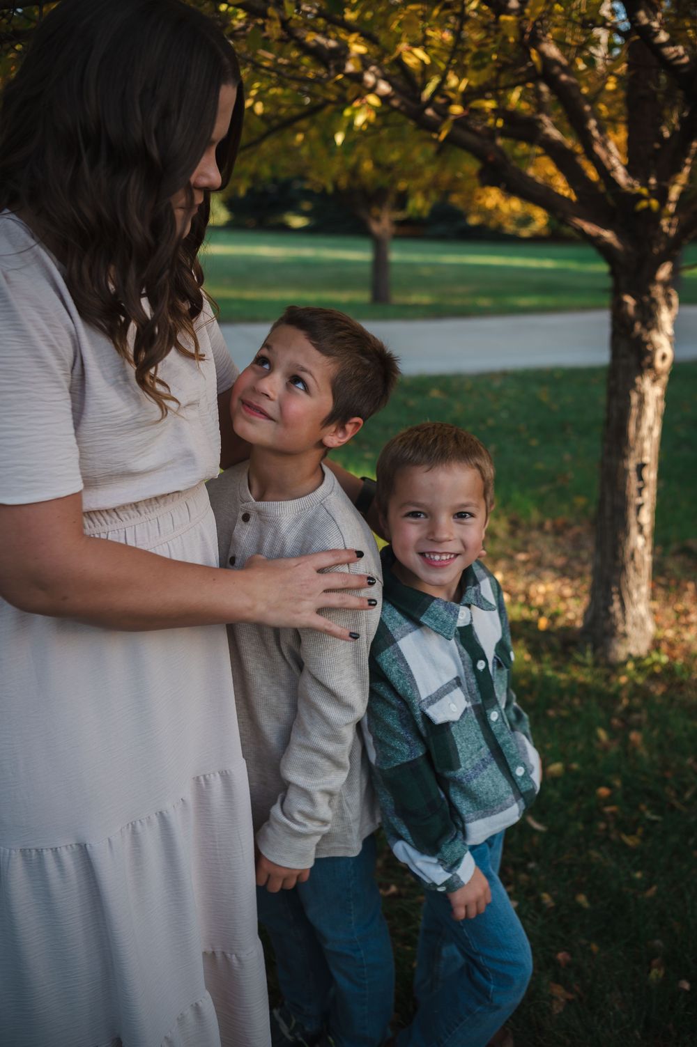 Playful outdoor family photoshoot with children in casual fall attire.