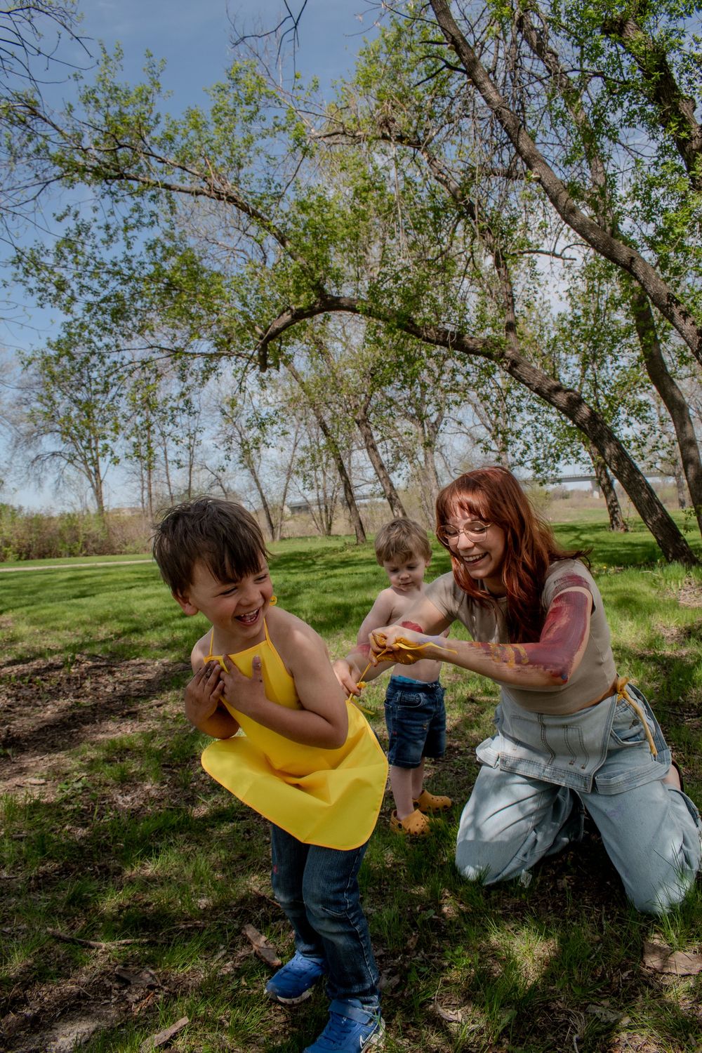 Playful moments captured in a grassy orchard on a sunny day.