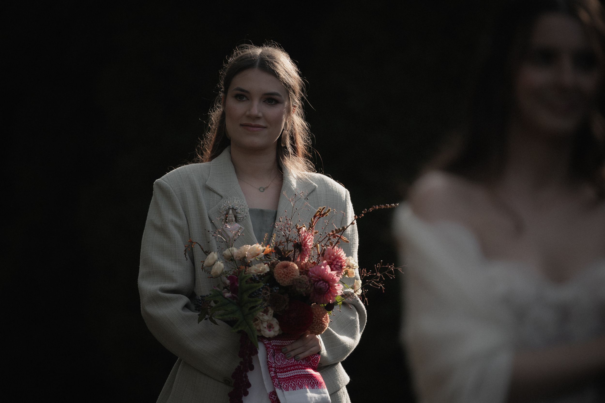 A series of wedding photos showing a bride in a white dress holding bouquets of pink and red flowers.