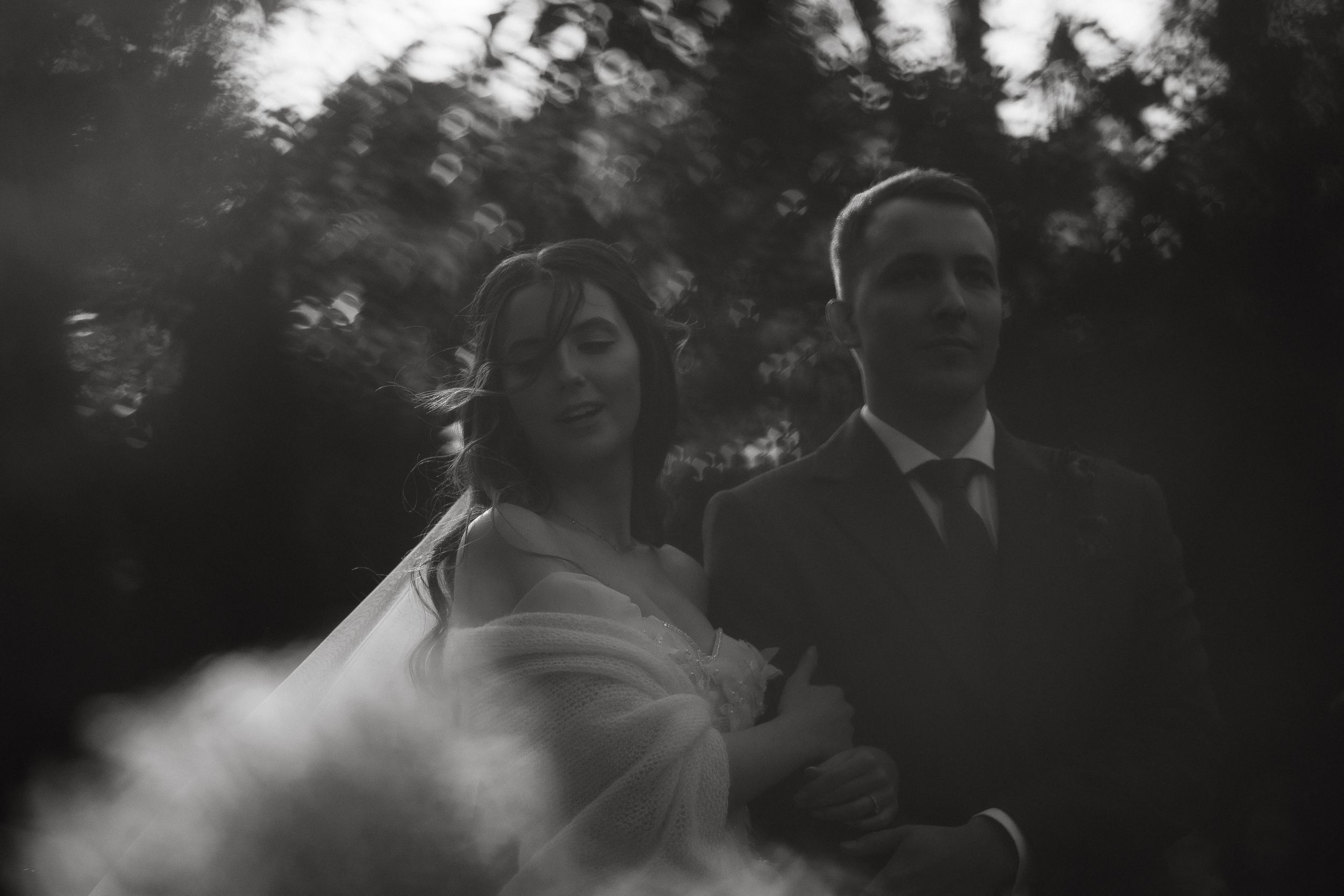A couple shares a romantic moment during their first dance at an outdoor wedding reception.