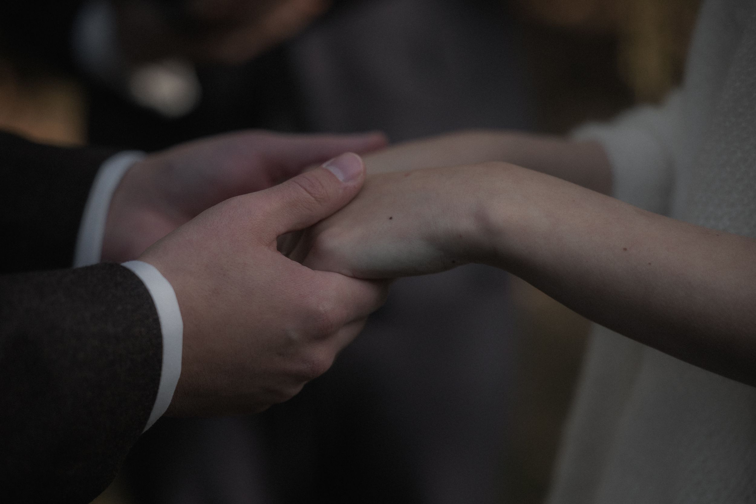 Close-up view of hands exchanging business cards in a professional setting.