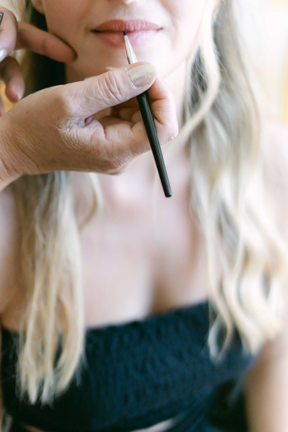 A close-up series showing someone applying lipstick in four sequential photos.