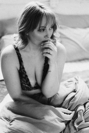 A series of black and white boudoir photos showing a woman in lace lingerie posing on bedding.
