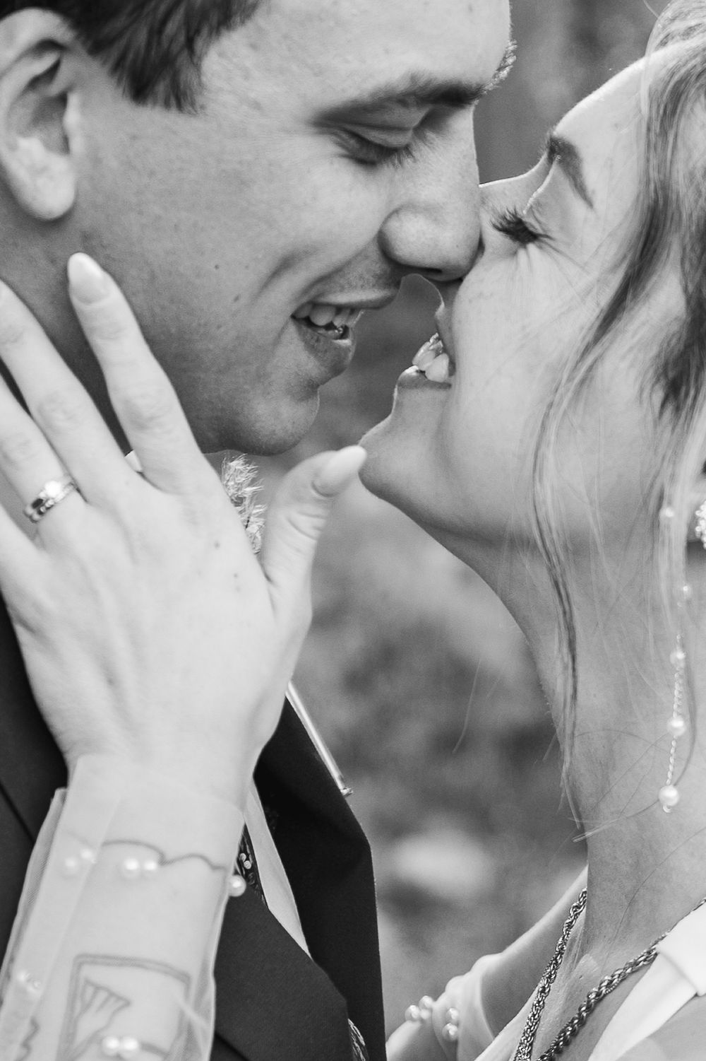A tender black and white romantic moment captured between a couple sharing an intimate close-up embrace.
