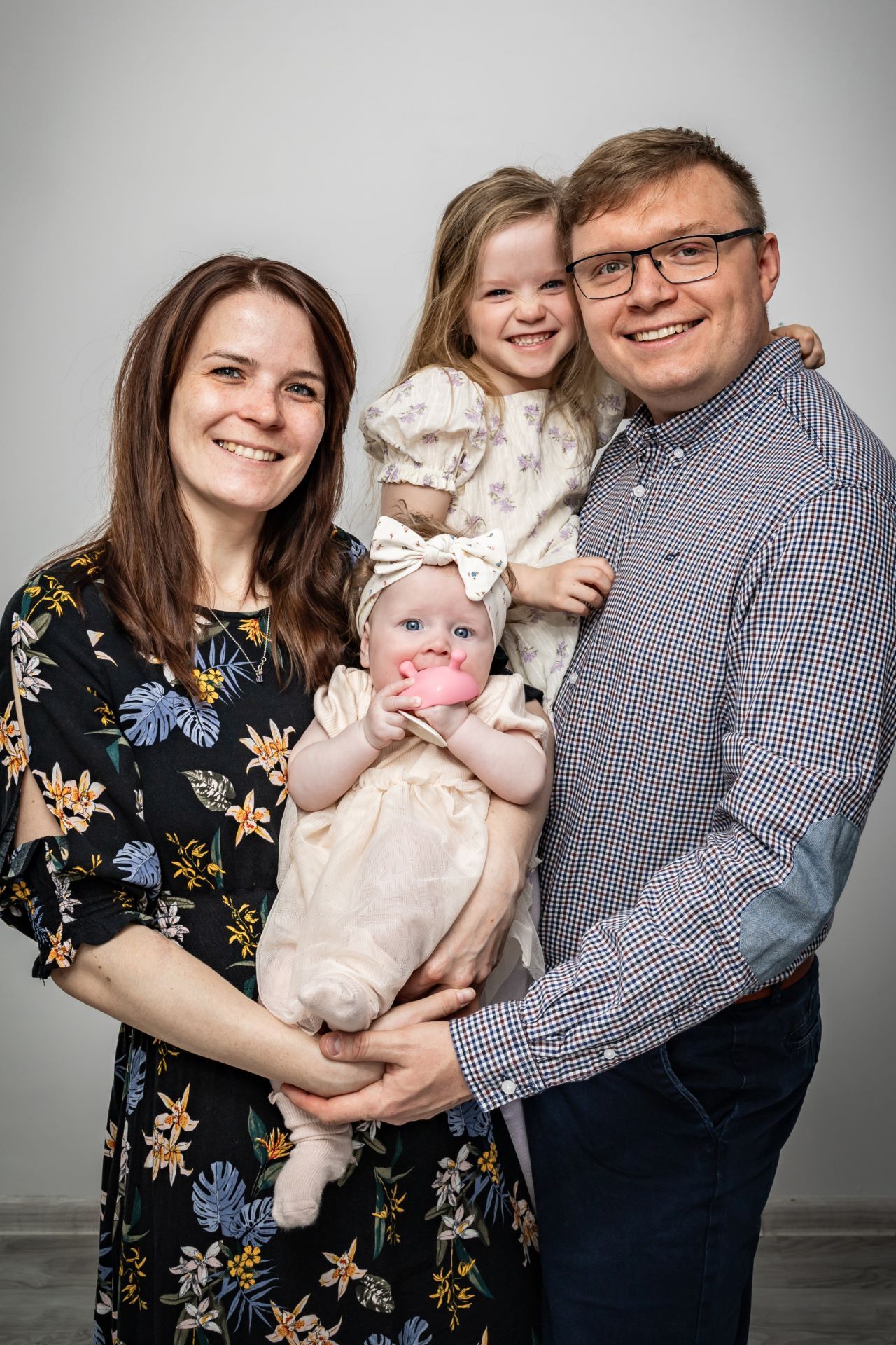 Family portrait session in studio against grey background.