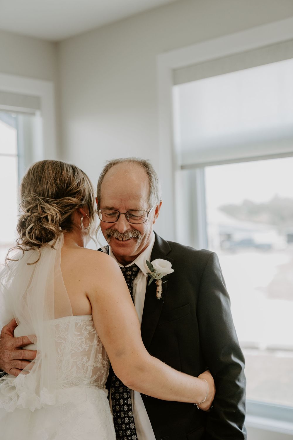 father embraces bride