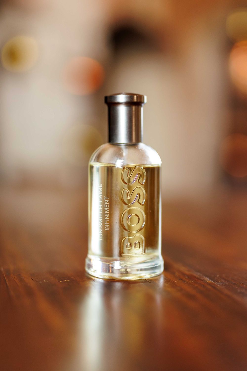 Close-up sequence of silver metallic perfume bottle caps with gold lettering on wooden surface.