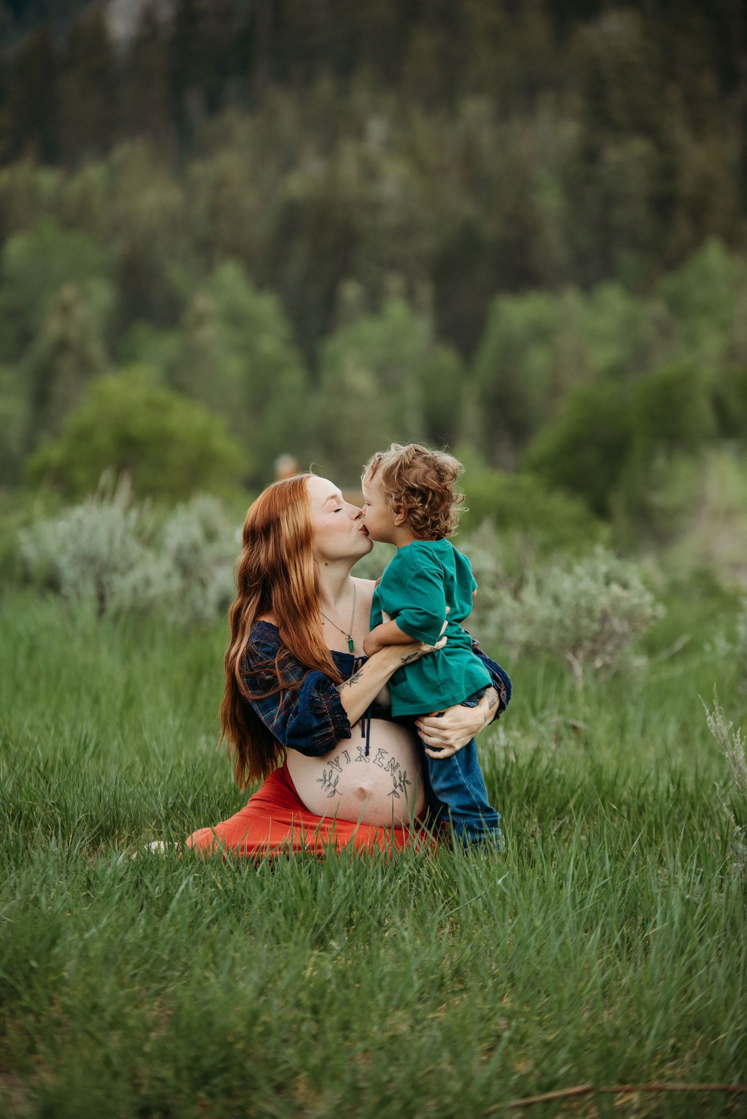 A tender moment shared between parent and child sitting in a lush green meadow on a spring day.