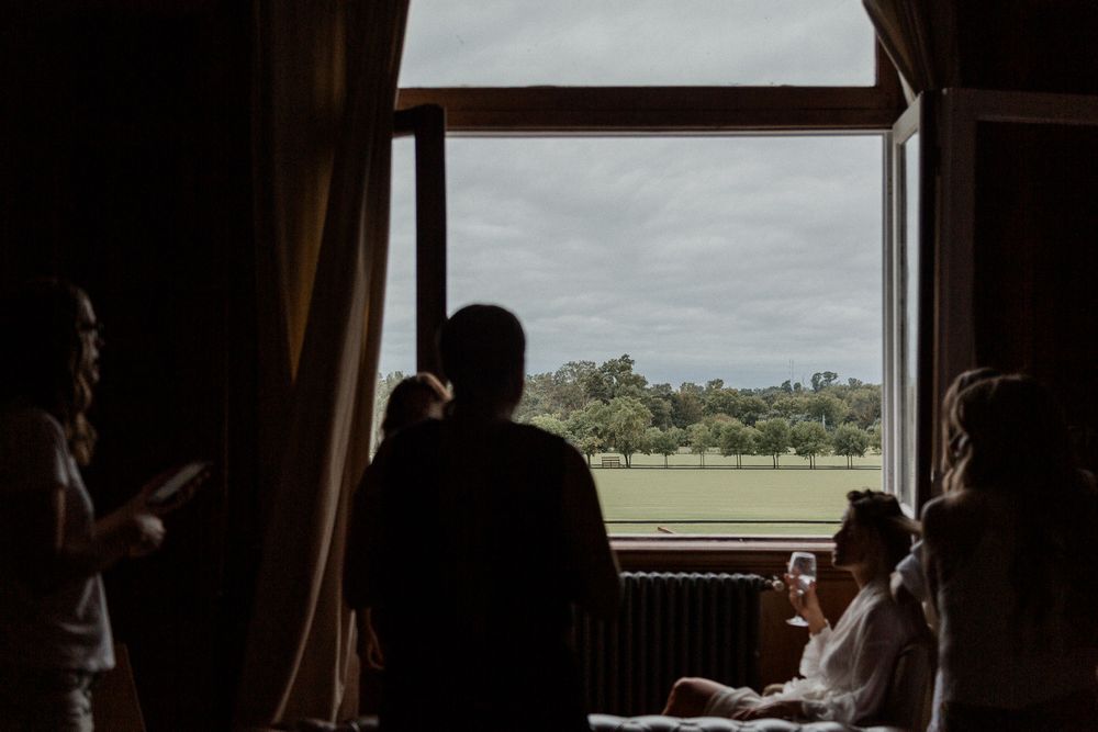 Silhouettes of people gathered by a window looking out at a cloudy landscape view.