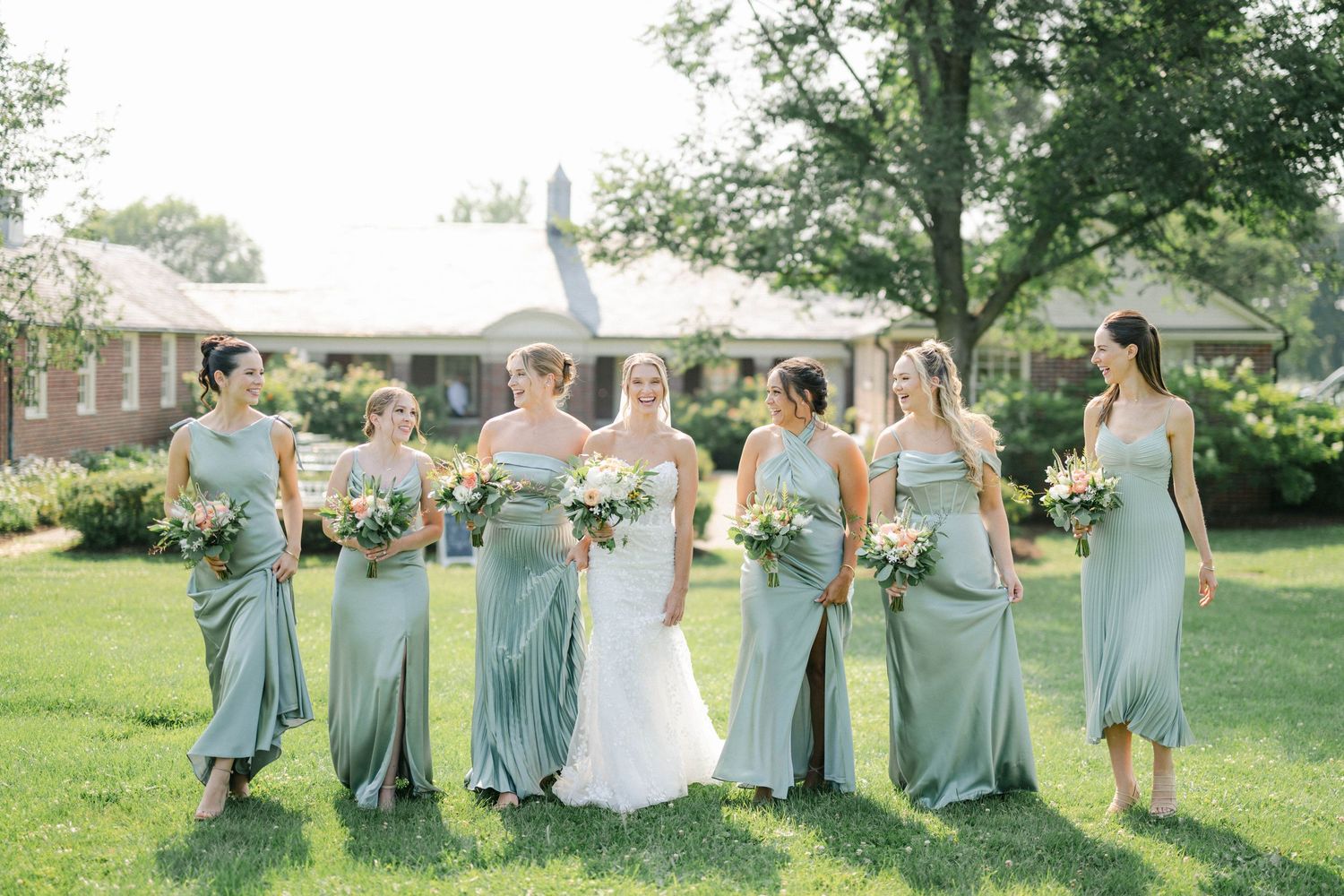 A sequence of five outdoor wedding photos showing bridesmaids in blue dresses celebrating on a sunny lawn. - Elawa Farm