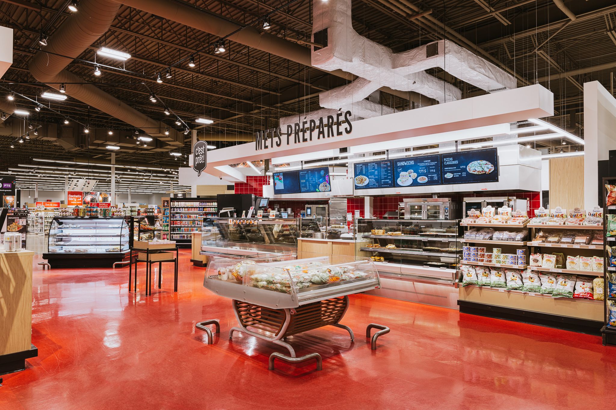 Wide angle panoramic view of modern retail grocery store interior with red floors.