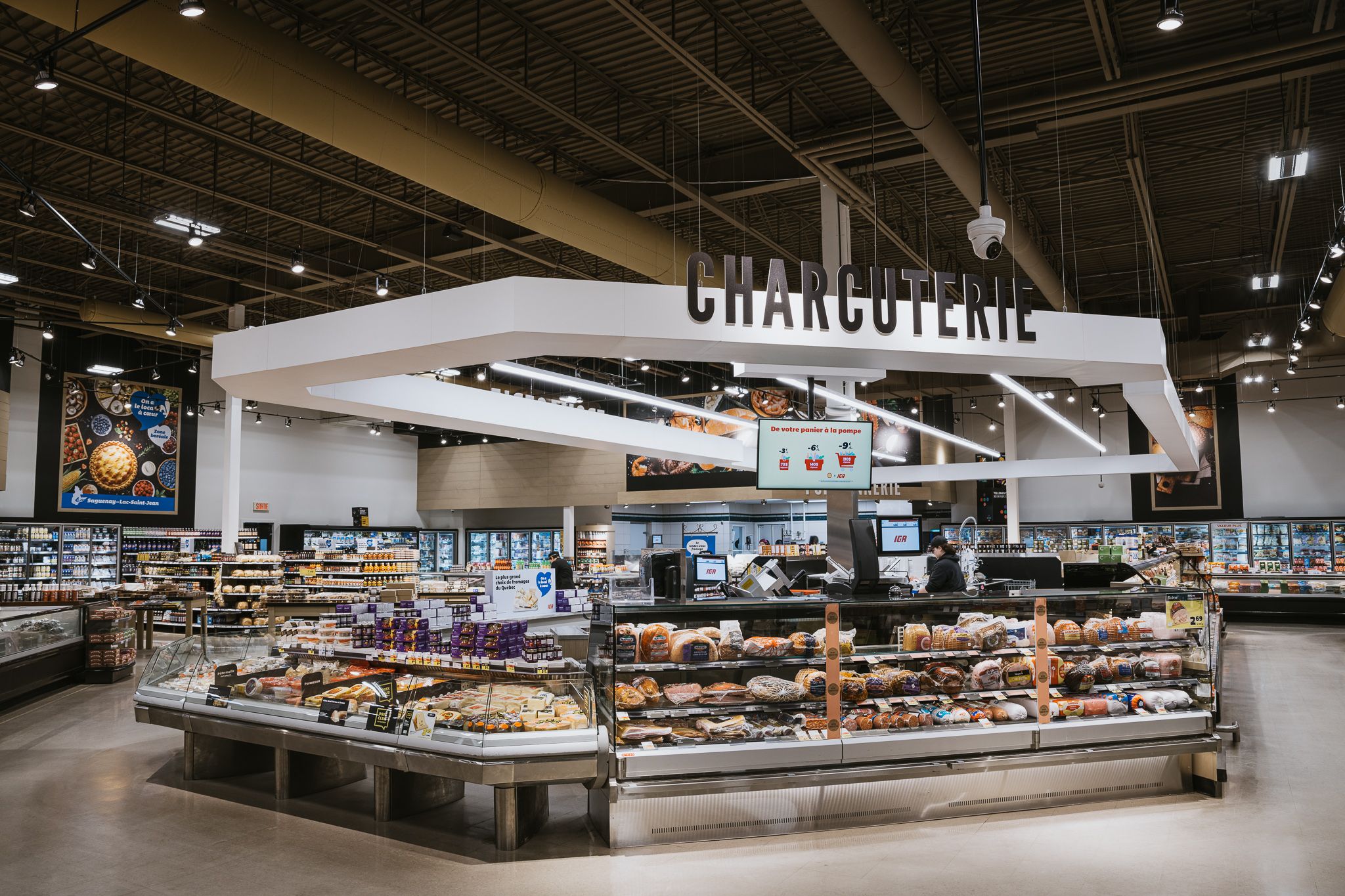 Charcuterie department in upscale grocery store with extensive deli case displays.