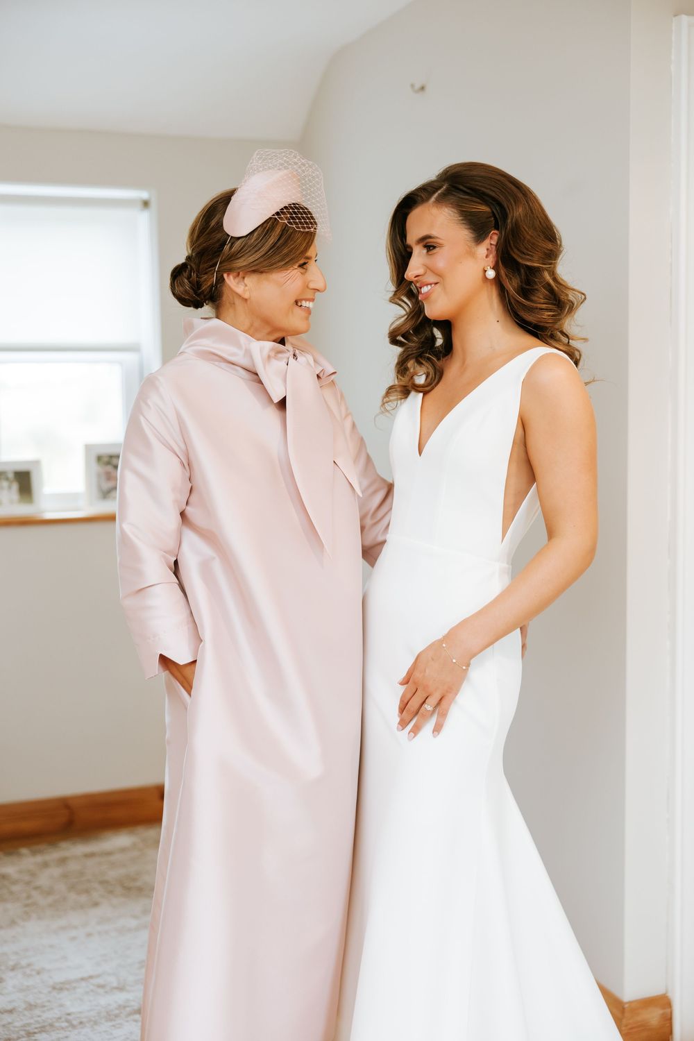 Two people share joyful moments together in a bright room while wearing white and pink outfits. Castle Leslie