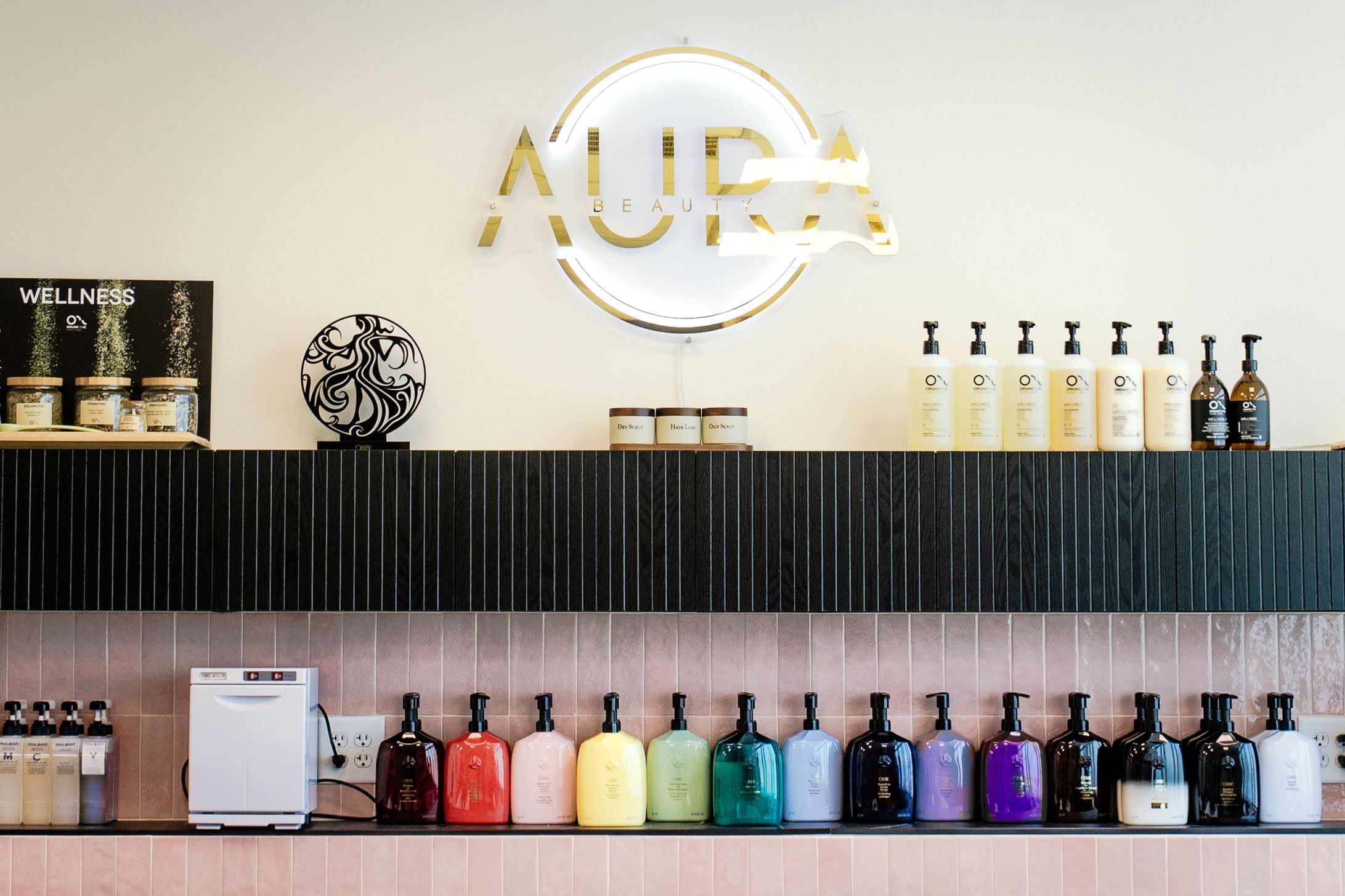 A series of colorful bottles and containers arranged in a row on a white shelf display.