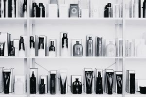 A row of black and white liquor bottles lined up on a shelf against a white background.