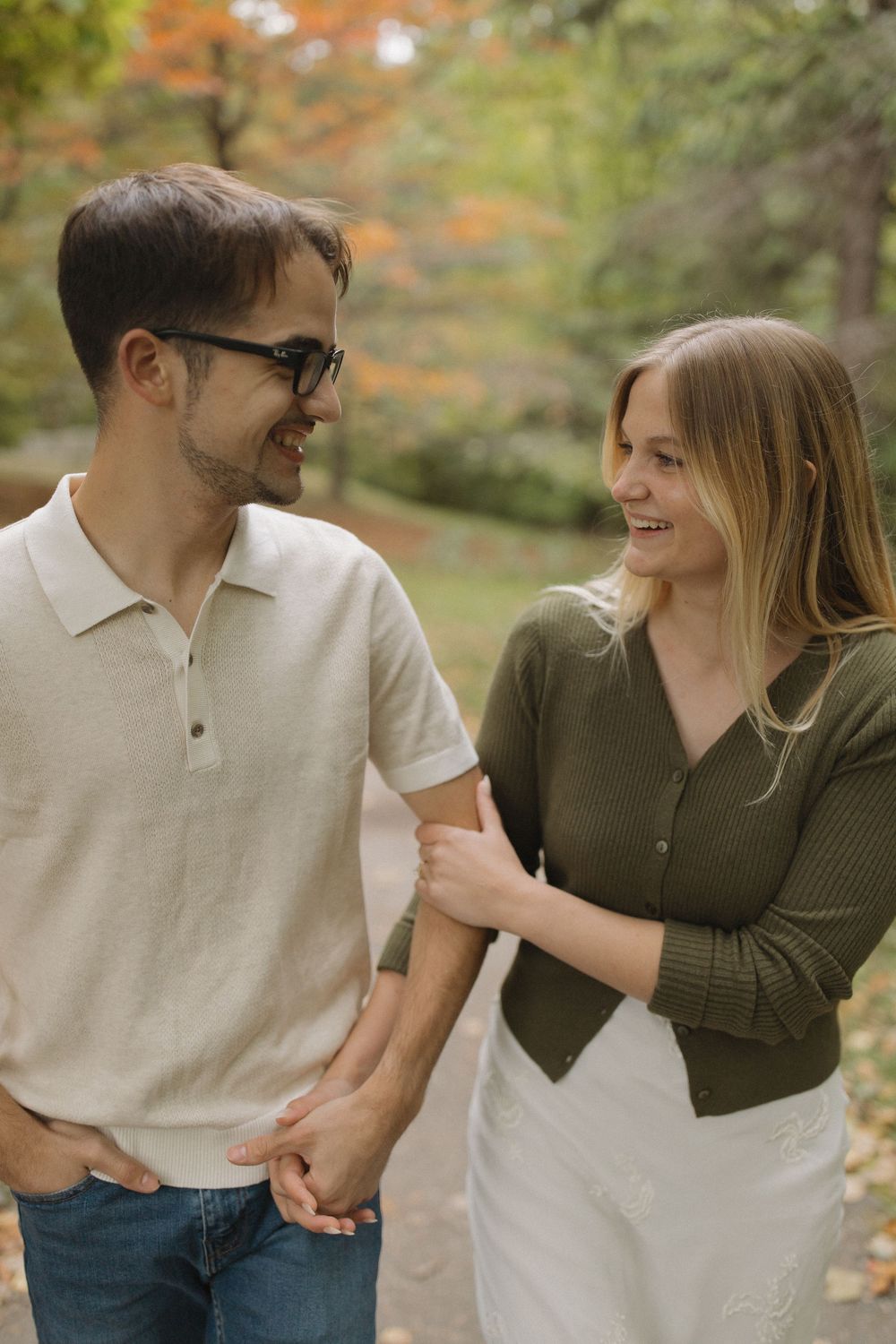 A couple shares a joyful moment together on an autumn day in the park.