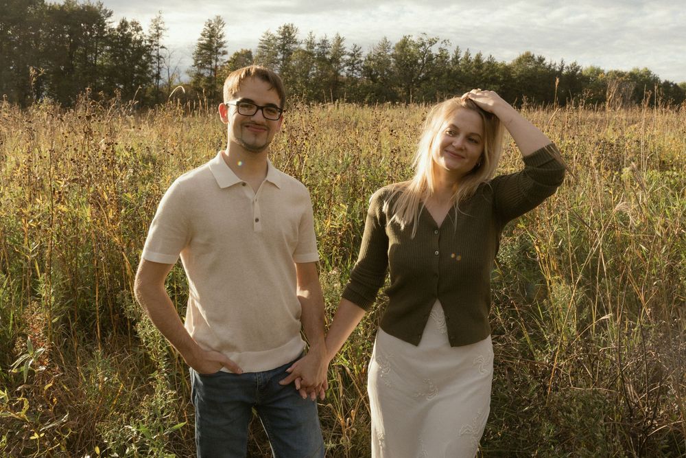 A couple shares intimate moments in a sun-drenched field of wild grasses.