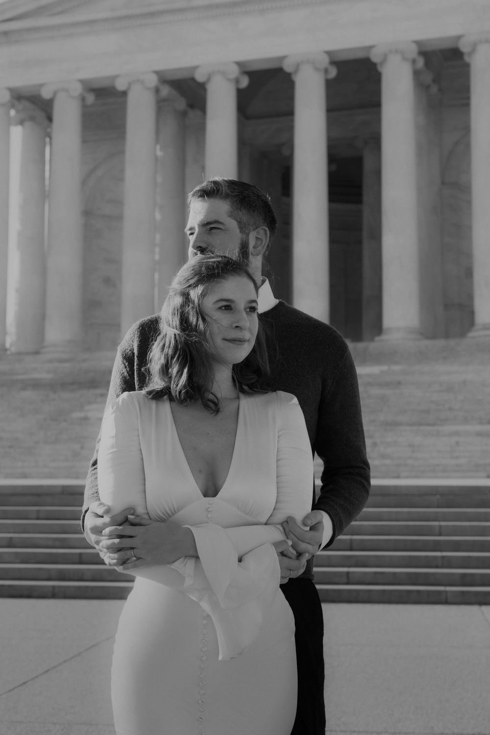 A romantic black and white photo session on grand stone steps with classical columns in the background.