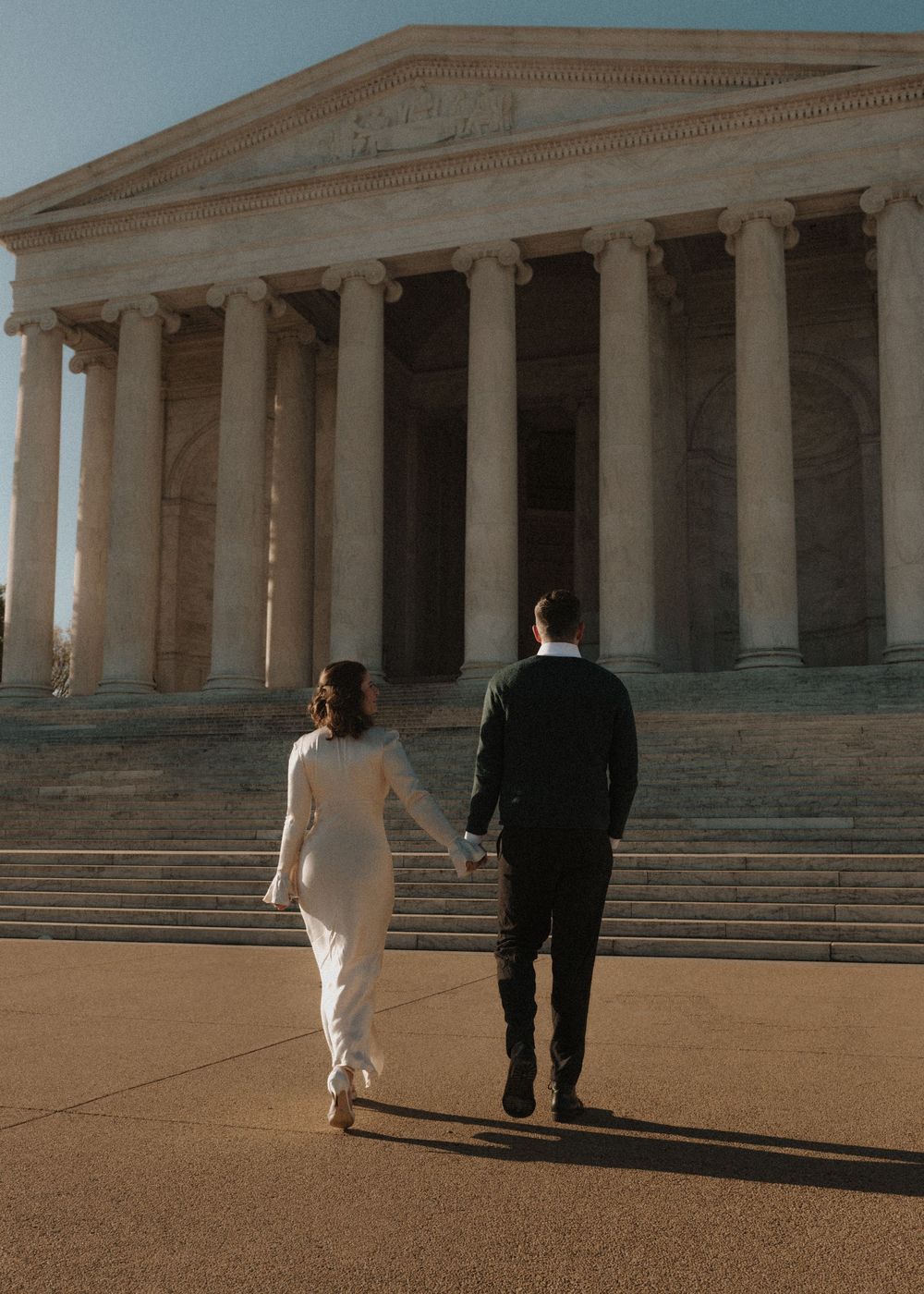 A couple ascends the grand steps of the Jefferson Memorial during a photo session.