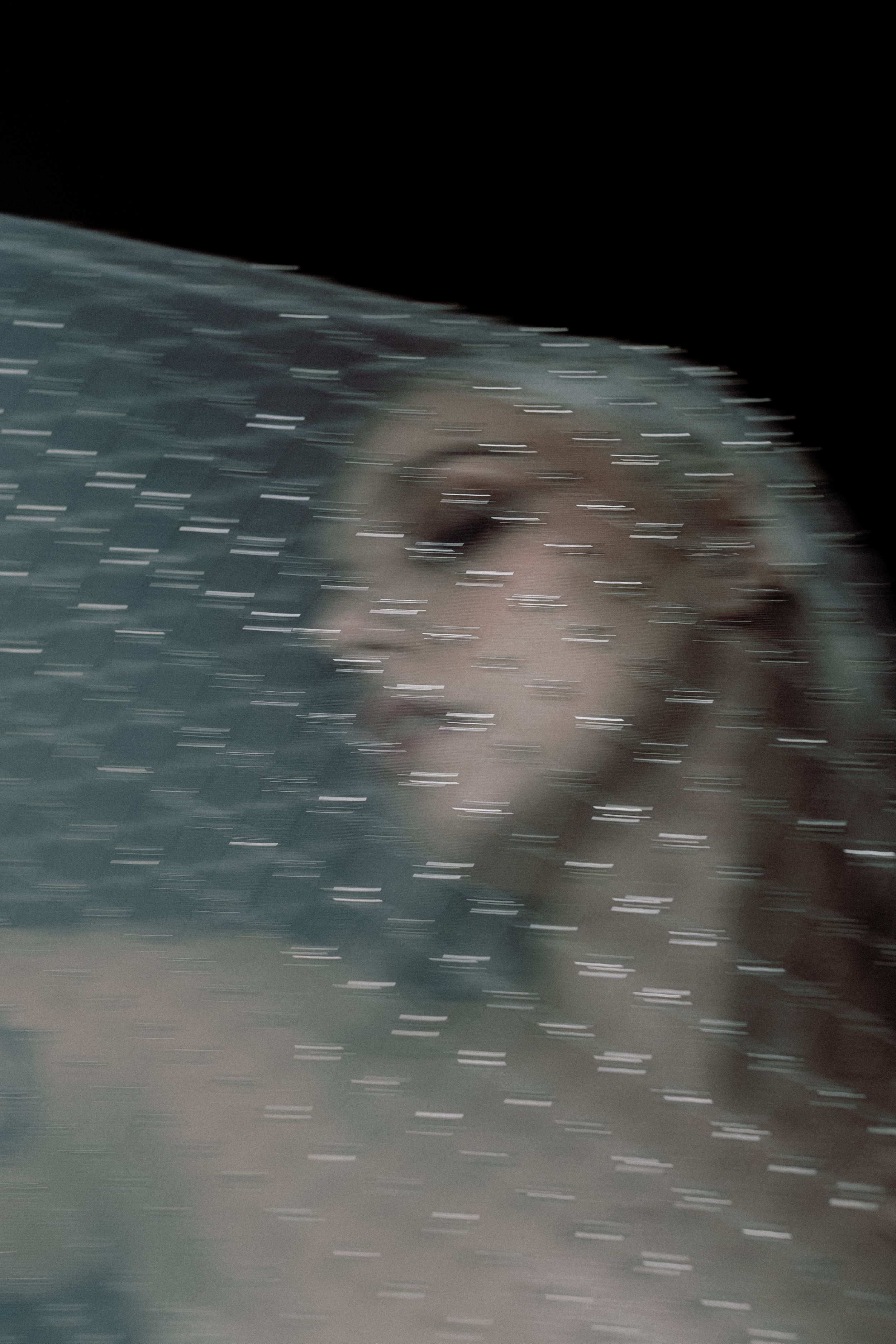 A blurry abstract image with horizontal streaks in muted teal and gray tones creates a motion effect.