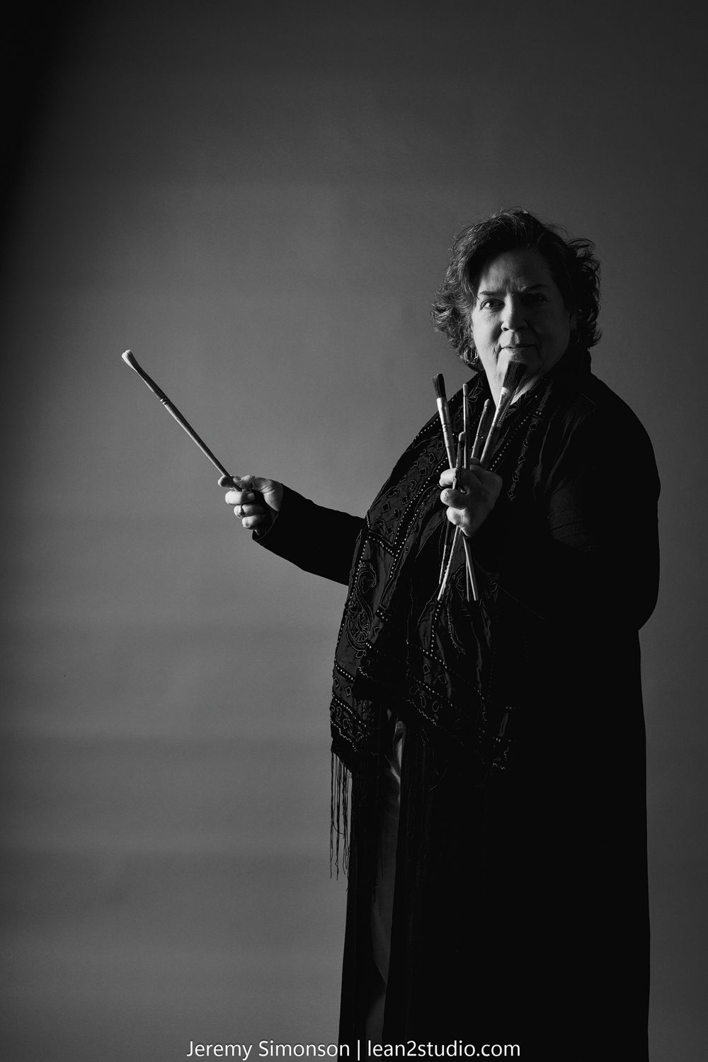 A dramatic black and white photo sequence shows a figure in dark clothing gesturing expressively against a stark background.