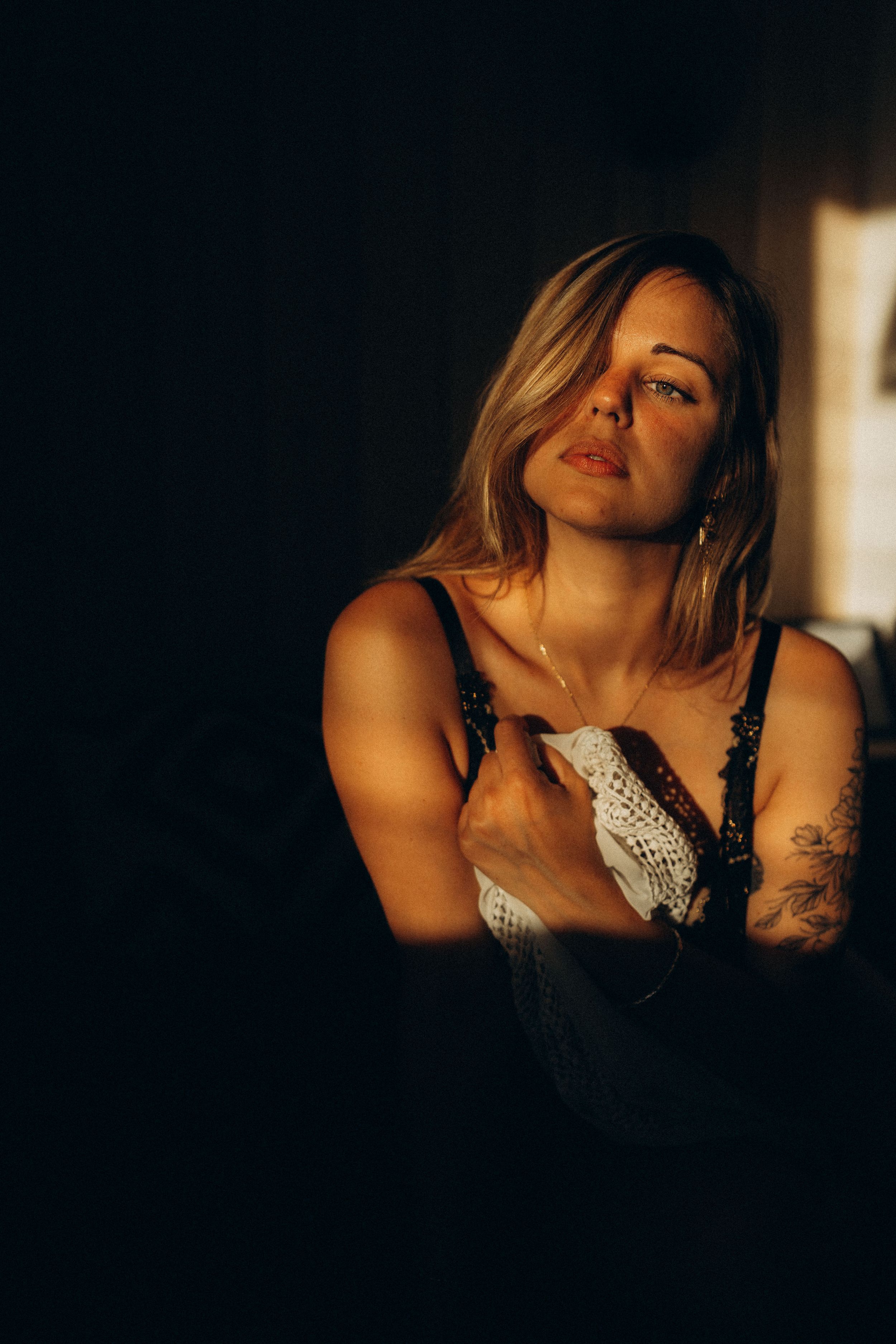 Artistic boudoir photo series in dark lighting shows intimate shadows and silhouettes against window light.